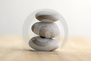 Stone cairn on striped grey white background, three stones tower, simple poise stones, simplicity harmony and balance, rock zen