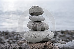 Stone cairn tower, poise stones, rock zen sculpture, light grey pebbles