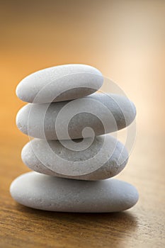 Stone cairn tower, poise stones, rock zen sculpture, light white pebbles on wooden background