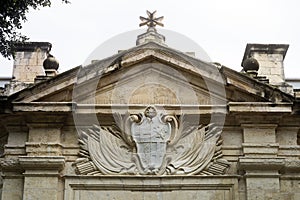 Stone Carved Coat Of Arms And Maltese Cross Above The Entrance