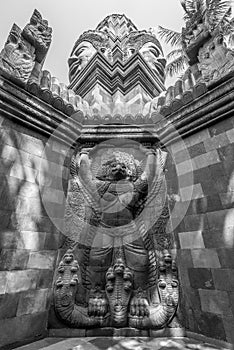 Stone carved Garuda surmounted by four stone faces of Bodhisattva Lokeshvara