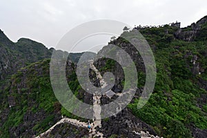Stone carved Hang Mua dragon sitting on top of famous Hang Mua peak in Vietnam