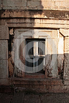 Stone carved with wooden iron door in Indian ancient Virupaksha Temple, Hampi, India.