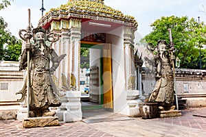 Stone carving giants infront of the gate of Wat Pho in Bangkok