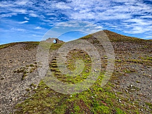 Stone castle archway on top of empty hill in Wales