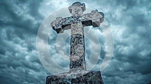 Stone catholic cross silhouetted against dramatic gray clouds for powerful imagery