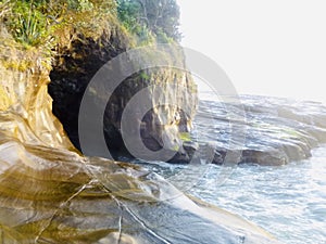 Stone cave at the Muriwai beach, while sunset.