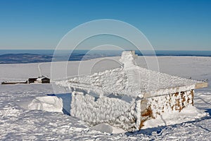 Stone chapel, memorial to the victims of the Giant Mountains, Czech republic. Winter sunny day.On background Meadow Hut