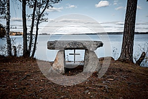 Stone Christian altar outdoors by a lake