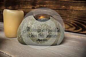 Stone with christian scripture with light candle