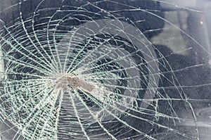 Stone or a cobblestone smashed the windshield as it flew into the car at speed. fragments and traces of a broken windscreen, textu