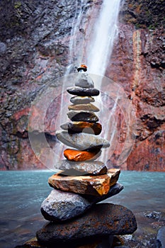 Stone column with bottom waterfall and a blue river