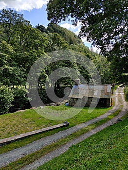 Stone cottage down winding lane besides a river in Wales