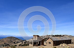 Stone cottage with thatched roof and stable on Isla del Sol in Lake Titicaca, Bolivia.
