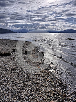 Stone covered lake shore and dramatic sky