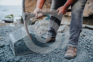 Stone craftsman carefully chipping at a block of cancagua stone to shape it photo