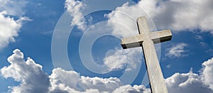 Stone cross agaist blue cloudy sky