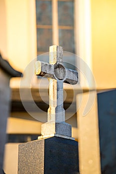 Stone cross on the cemetery, evening sun