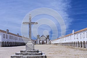 Stone cross in front of a Baroque Church and Sanctuary