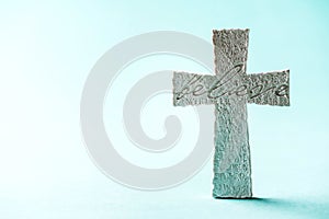 Stone cross with inscription Believe on blue background, Copy space. Christian backdrop. Biblical faith, gospel