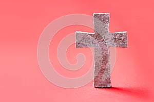 Stone cross with inscription Believe on red background, Copy space. Christian backdrop. Biblical faith, gospel