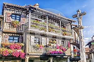 Stone cross and typical architecture in main square of La Alberca.Spain photo