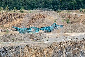 Stone crusher in the quarry. Working mining machine - stone crusher. Quarrying of stones for construction works. Mining industry. photo