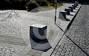Stone cubes barriers as protection of a nice lawn cube cubes on a paved sidewalk platform of a tram protected from the entry of ca