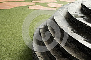 Stone and curve staircase on artificial turf and brown stone