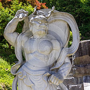 Stone demon guard statuesque, guardian statue at the entrance to the Korean Buddhist Temple Guinsa. Danyang Region, South Korea,