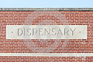 Stone dispensary sign on a brick building