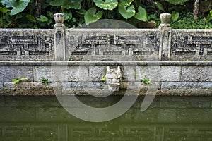 The stone dragon head on the wall in the garden