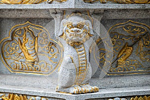 Stone dragon statue with golden colored ornaments in a buddhist temple