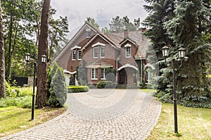 Stone driveway to house in english architectural style in the forest. Real photo
