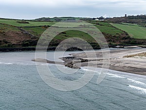 A stone embankment on the shore of the Atlantic Ocean. Seaside landscape. Warren Beach. Green grass field near water