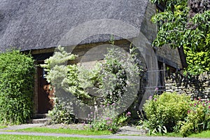 Stone english house with flower, shrub, tree garden