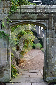 Stone entrance leading to a formal garden.