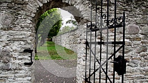 Stone entrance with an old medieval black steel gate