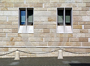 stone facade detail with narrow vertical glass windows with stone frame