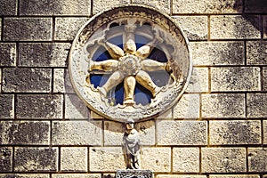 Stone facade of old catholic church with round window, Dubrovnik, Croatia