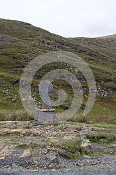 Stone famine memorial in Doo Lough Valley of Connemara, Ireland with rocky hillside in background