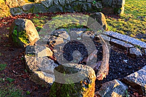 Stone fire pit with rockes around covered in moss