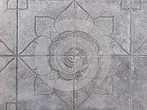 Stone floor tiles with 4-petal lotus flower motif, seen here on the grounds of a Buddhist temple in Thailand