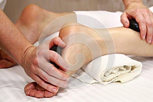 Stone foot massage, detail. Patient receiving foot massage.