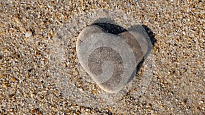 Stone in the form of a heart in the sand, as a symbol of love.