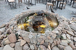 Stone fountain with light among local park in town. Public area for outdoor activity on holiday. Zen fountain in garden. Round