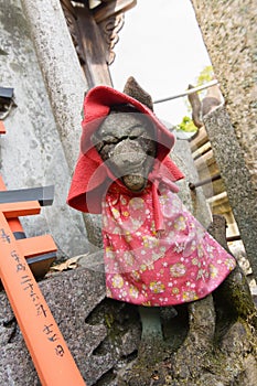 Stone fox statue with red cap.