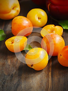 Stone fruits on wooden background. Yellow plums, apricots and nectarines