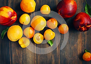 Stone fruits on wooden background. Yellow plums, apricots and nectarines