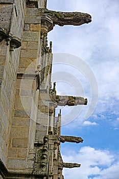 Stone gargoyles on the facade of the Gothic Basilica of Notre Dame du Roncier in Josselin, France.